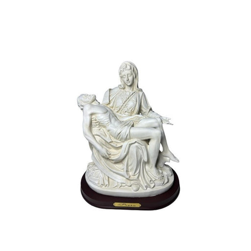 White Pietà statue featuring the Blessed Virgin Mary holding Jesus after the Crucifixion, displayed on a brown wooden base with a “Pieta” nameplate. Elegant Catholic devotional décor for home altars, prayer spaces, and memorial displays.