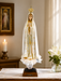 12-inch Our Lady of Fatima statue in ivory resin with finely sculpted robes and serene expression, depicted standing in prayer on a simple base with traditional Marian detailing.