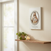 Good Shepherd relief wall plaque by Joseph Studio mounted on a wall with a candle below
