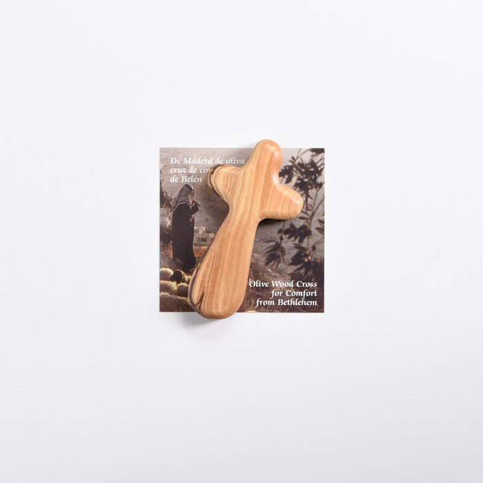 Rounded olive wood comfort cross with natural wood grain on its Bethlehem presentation card.