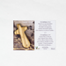 Olive wood comfort cross beside its card showing 2 Corinthians 1:3–4 in English and French.