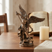 St. Michael statue styled on a wooden prayer table with a candle and open Bible